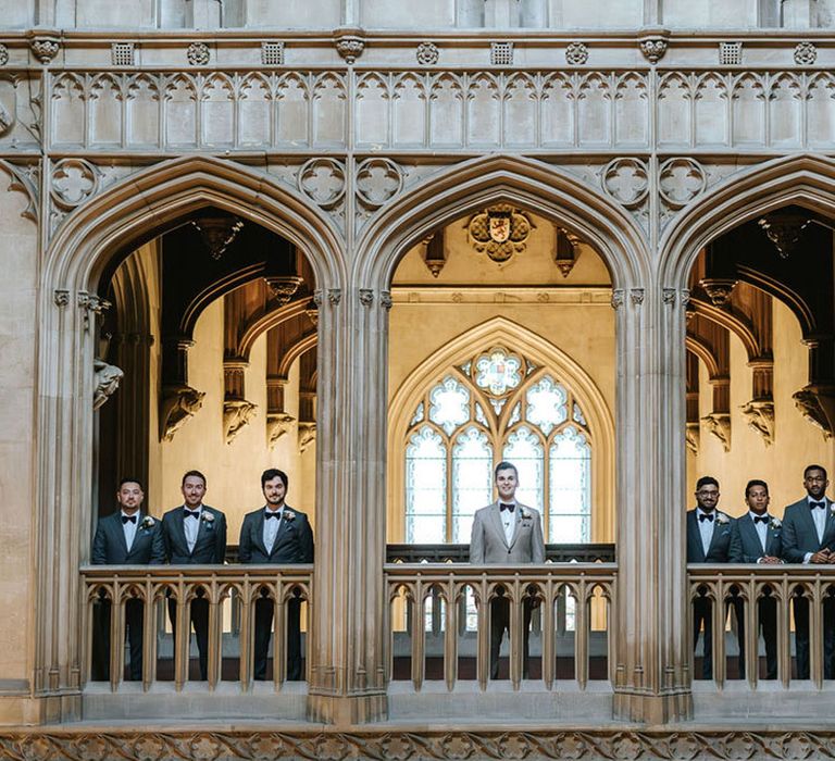 Ashridge House wedding venue in Hertfordshire with the groom and groomsmen looking over the balconies 