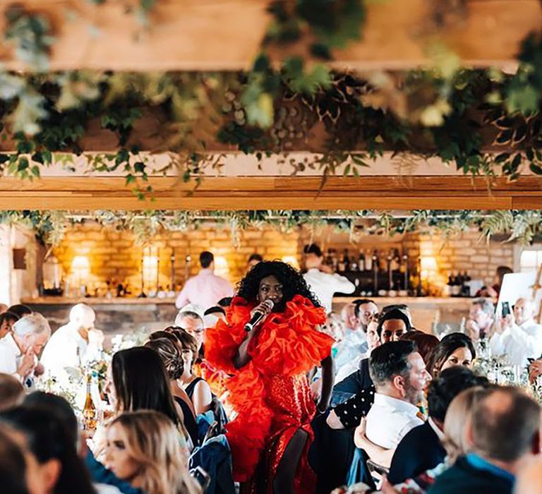 Wedding singer wearing elaborate red dress performing at the reception 