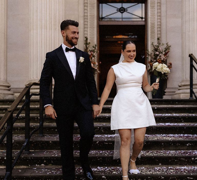 Bride in an Alex Perry short wedding dress and white coat for a winter wedding 