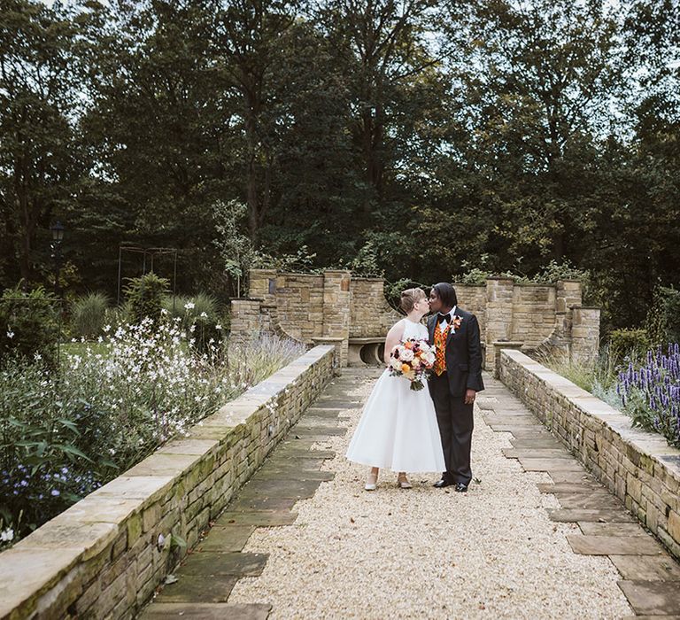 Two brides at Bowcliffe Hall wedding venue walking hand in hand 