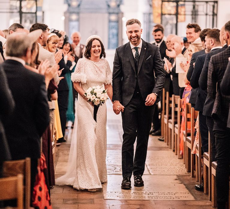 The bride and groom walk back down the aisle as a married couple 