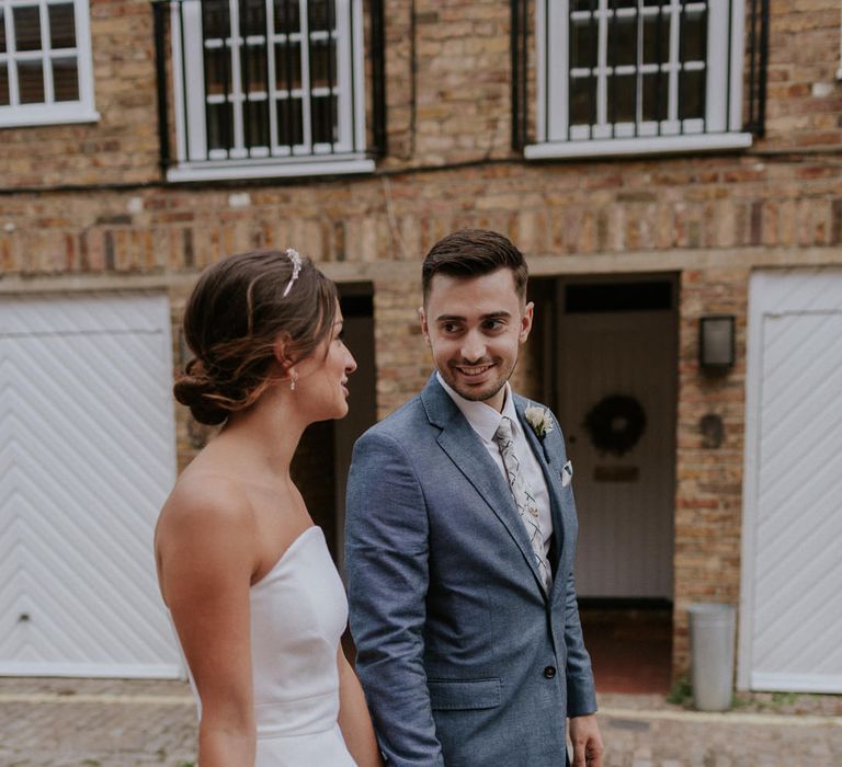 Bride in Roland Mouret wedding dress holding hands with her groom