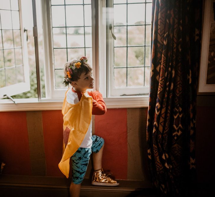 Paige boy in shorts, cape, trainers and flower crown for rainbow wedding 