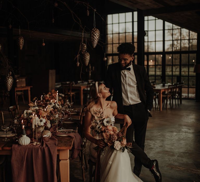 Bride and groom sitting at a winter tablescape with cost candlelight 