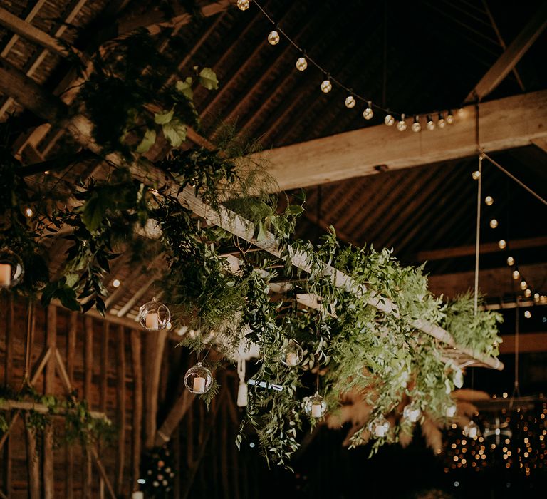 Hanging wooden ladder covered in foliage 