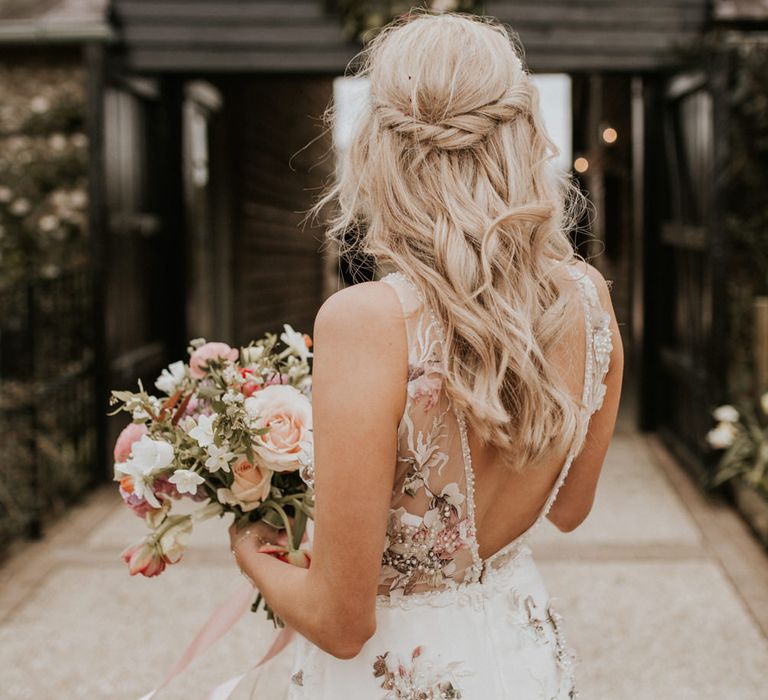 Bride in floral embroidered wedding dress with half up half down hairstyle