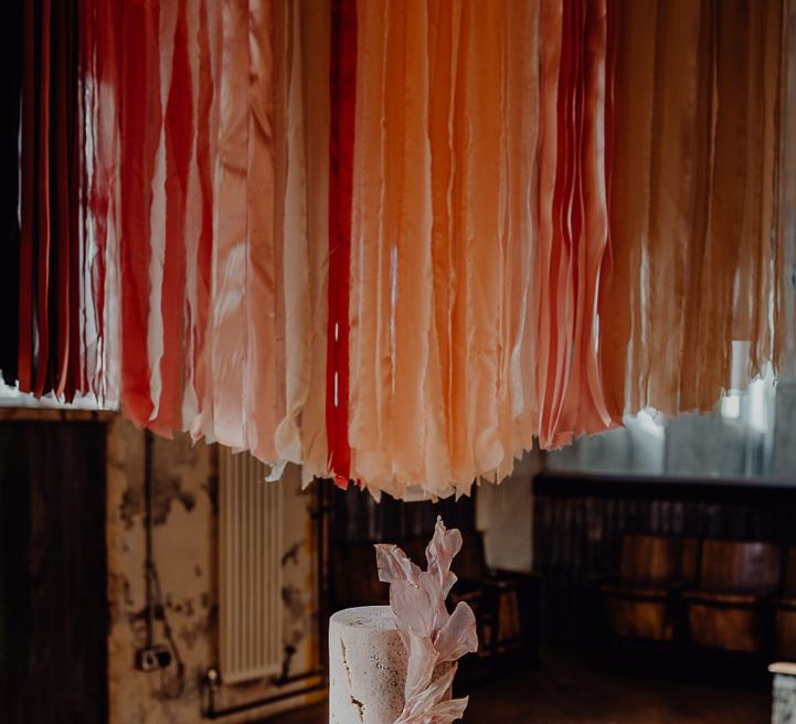 Single tier wedding cake with streamer backdrop 