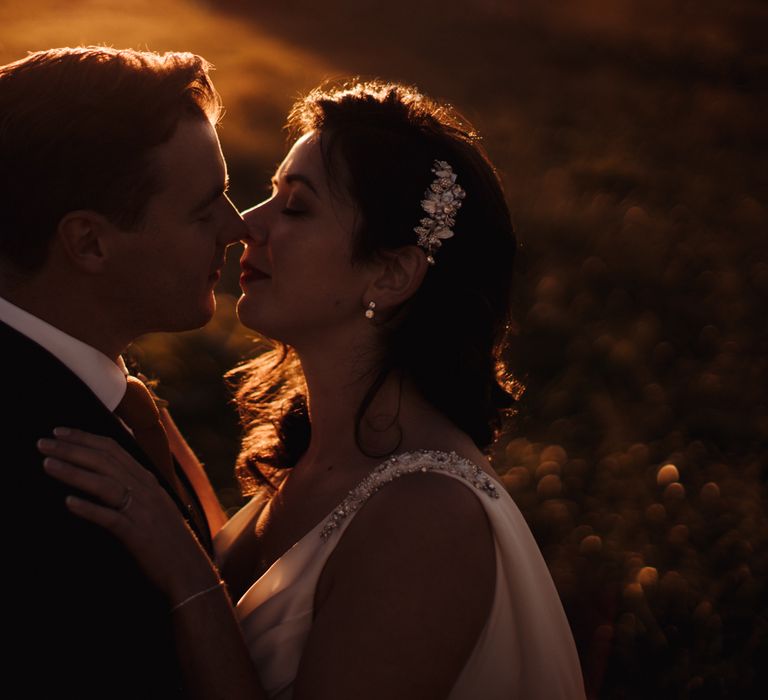 Bride & groom kiss during golden hour