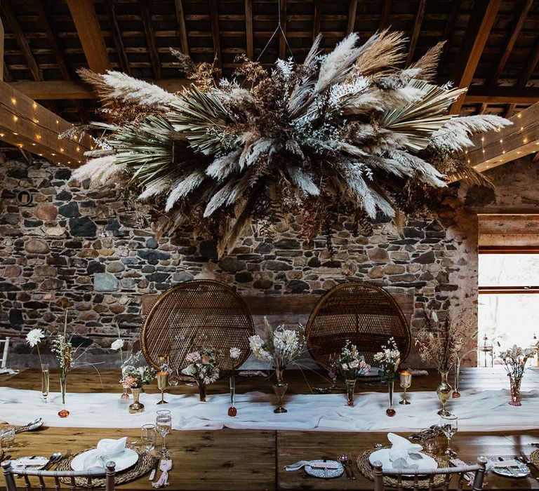 Boho wedding table setting with pampas flower cloud and rattan chairs