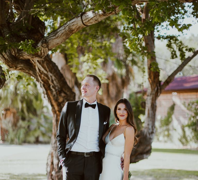 The bride and groom pose after their outdoor wedding ceremony