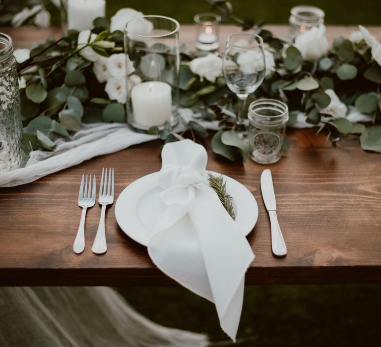 Simple white napkins with rosemary leaves as place settings