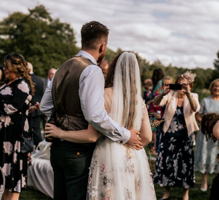 Bride & groom in front of wedding party 