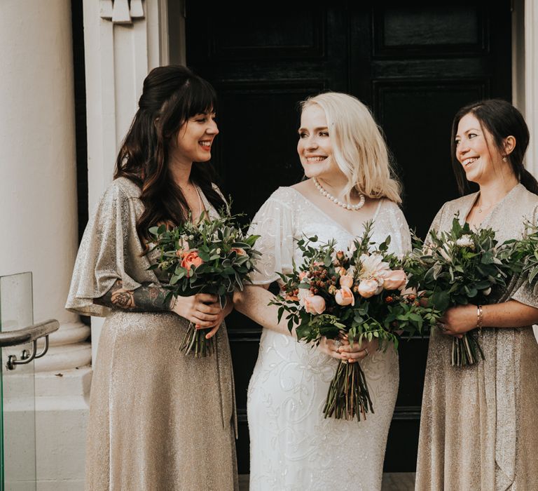 Bride laughs with her bridesmaids on wedding day