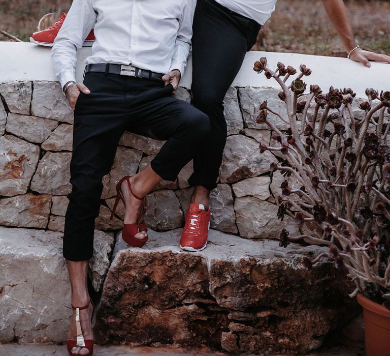 Couple portrait at drag race wedding inspiration shoot. The grooms sit on a wall. Photography by Stephanie Shenton.