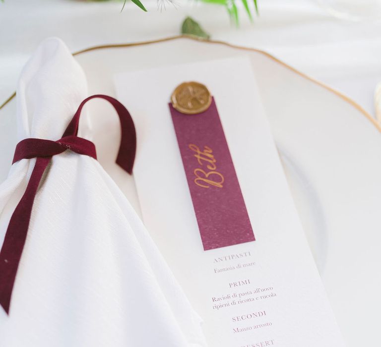 Minimal white wedding table setting with burgundy details