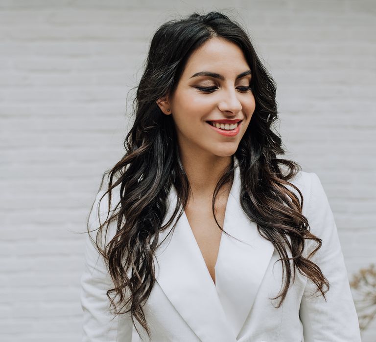 Laid back loose curls bridal hairstyle with white bridal blazer