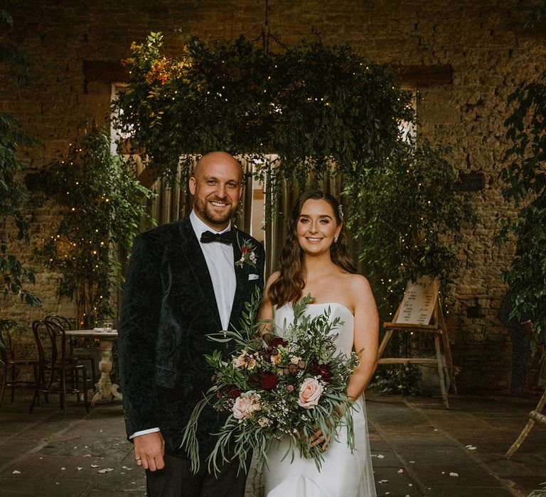 Portrait of the bride and groom inside their wedding venue Cripps Barn decorated in natural wedding flowers decor 