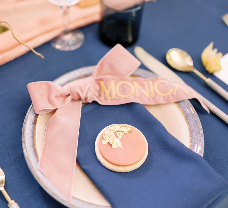 Tablescape complete with pastel pink biscuit favours complete with gold leaf on blue napkins