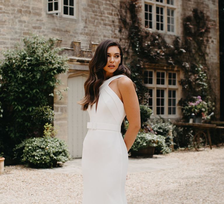 Beautiful bride with long barrel curls in an A line wedding dress with halter neck