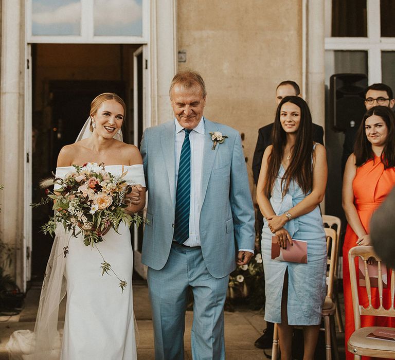 Bride walks down the aisle on her wedding day with her father 