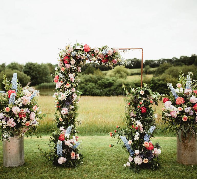 Colourful floral archway for outdoor wedding day