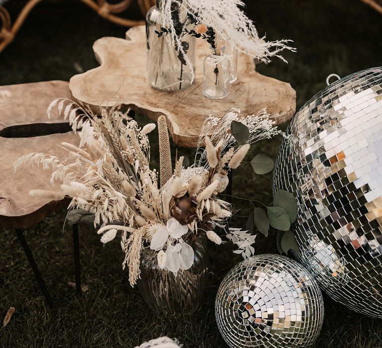 Dried florals in clear vase on wooden plank