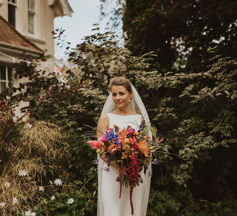 Beautiful bride in a Charlie Brear wedding dress with high neck and polka dot cathedral length Rebecca Anne Designs wedding veil 