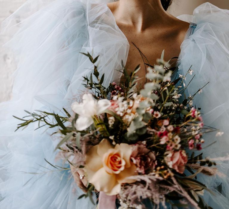 Bride in a pale blue coloured wedding dress wearing a dried flower crown 