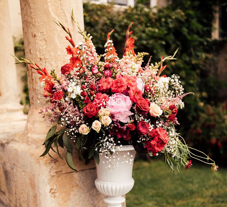 Large floral installation for wedding with red, white and pink mixed florals including roses and gypsophila 