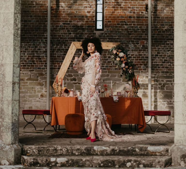 Black bride in a pink embroidered wedding dress in red velvet shoes at Chiddingstone Castle 