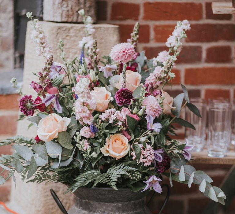 Assorted flower display of orange, pink, white and purple including roses and gladiolus with greenery 