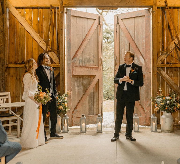 Nancarrow Farm wedding ceremony with black tie dress code and bride in lace Rosa Clara dress, silver lanterns with candles and vintage milk churns 