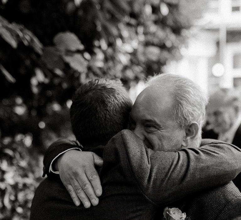 Groom hugs father on wedding day