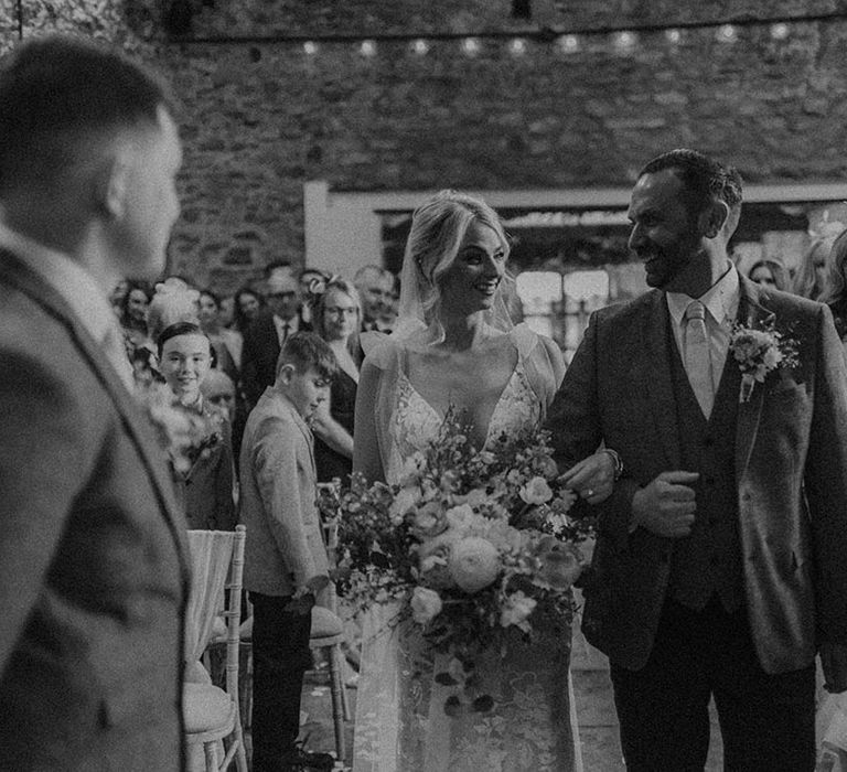 Father of the bride walks the bride in Made With Love dress down the aisle to groom at Eden Barn wedding venue 