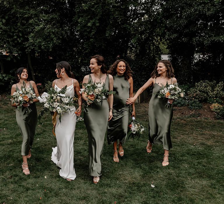 Bride and bridesmaids in white and sage green satin dresses 