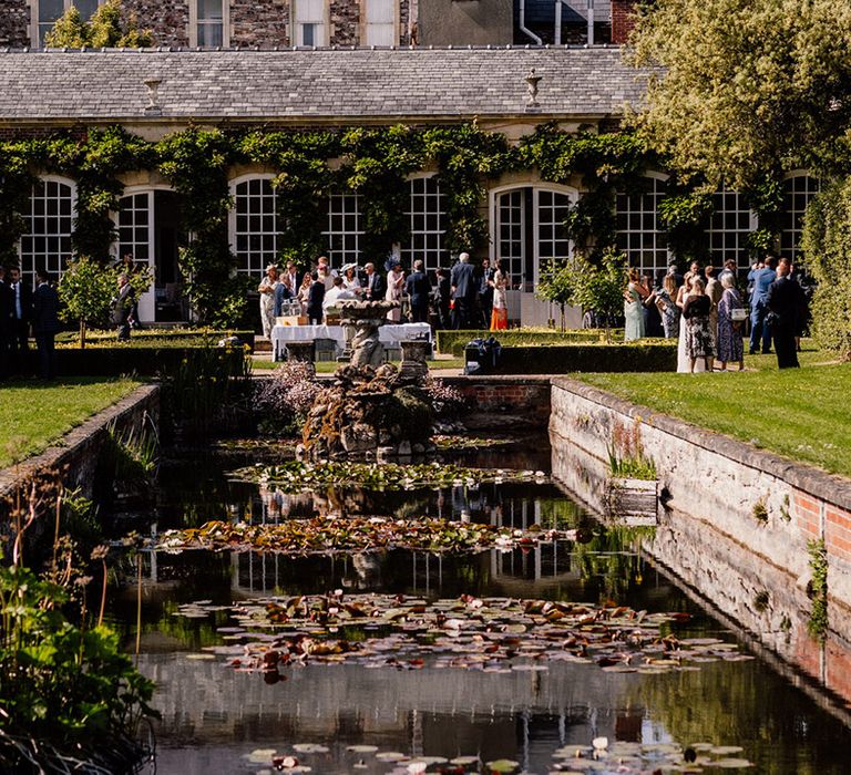 Wedding guests socialise outside together at the Goldney Hall wedding venue