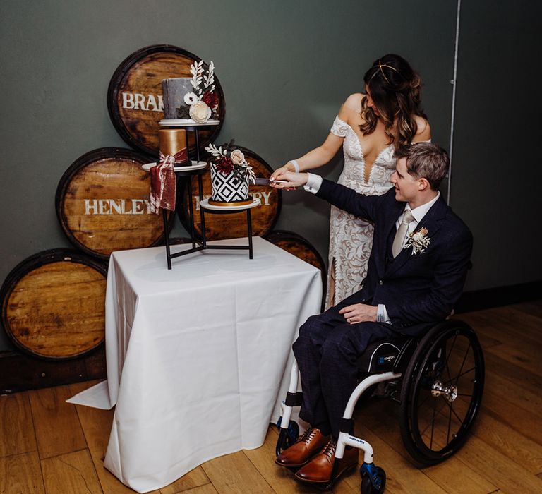 Bride and groom cut their geometric black and white patterned wedding cake 