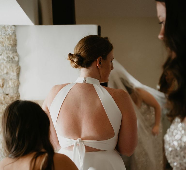 Bride wears Halfpenny London wedding dress with tie to back and open design with buttoned neck