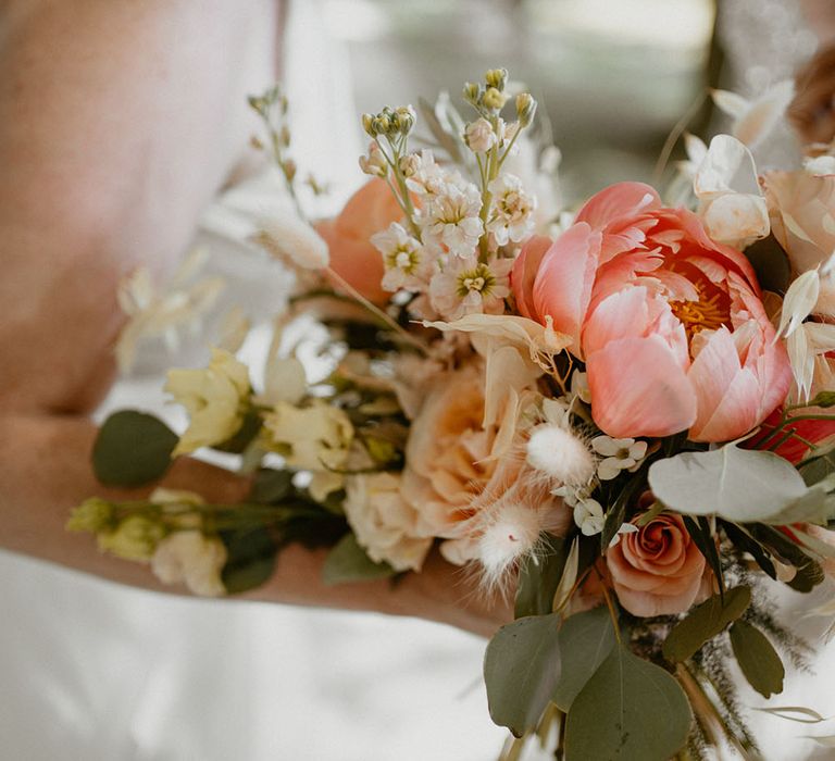 Pink peony bridal bouquet complete with bunny ears and pale pink roses with green foliage 