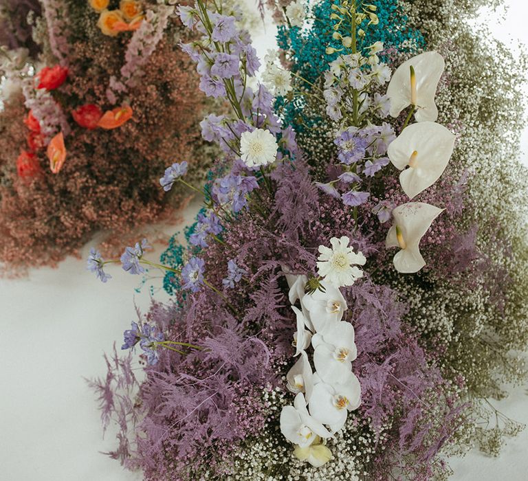 Purple, blue and white gypsophila wedding flowers with anthuriums, orchids and roses