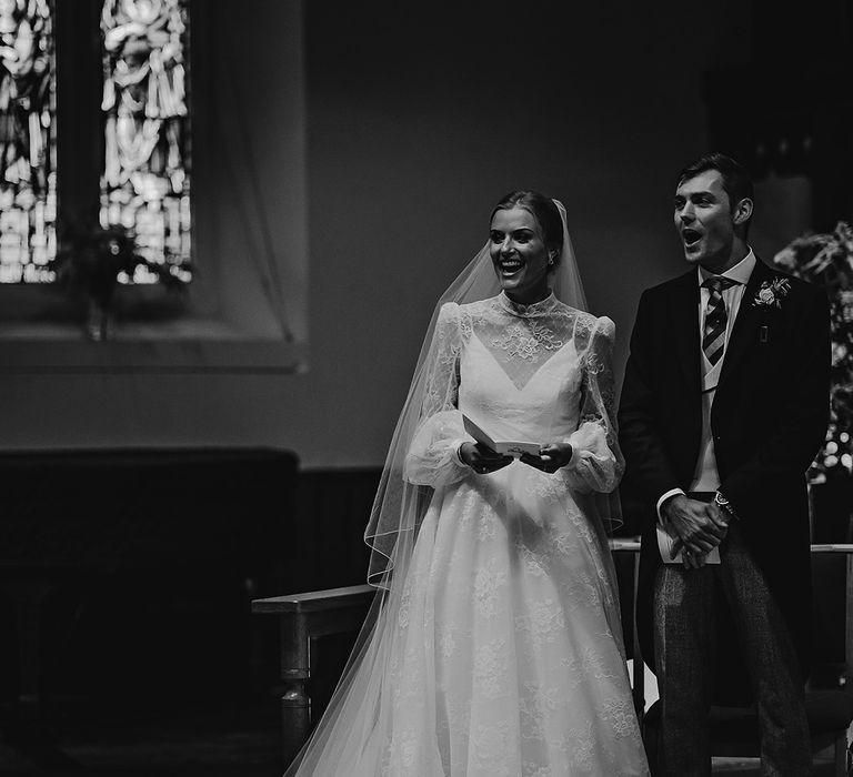 Bride and groom stand and smile as they participate in their wedding ceremony 