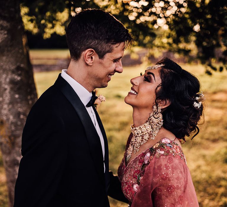 Bride & groom look lovingly at one another during couples portraits outdoors 