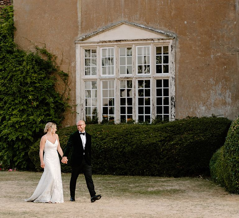 Bride & groom walk outdoors at Bisham Abbey after wedding ceremony