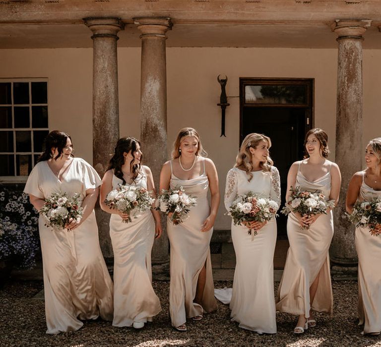 Bridesmaids in champagne gold dresses with the bride in a Badgley Mischka wedding dress for classic boho luxe wedding