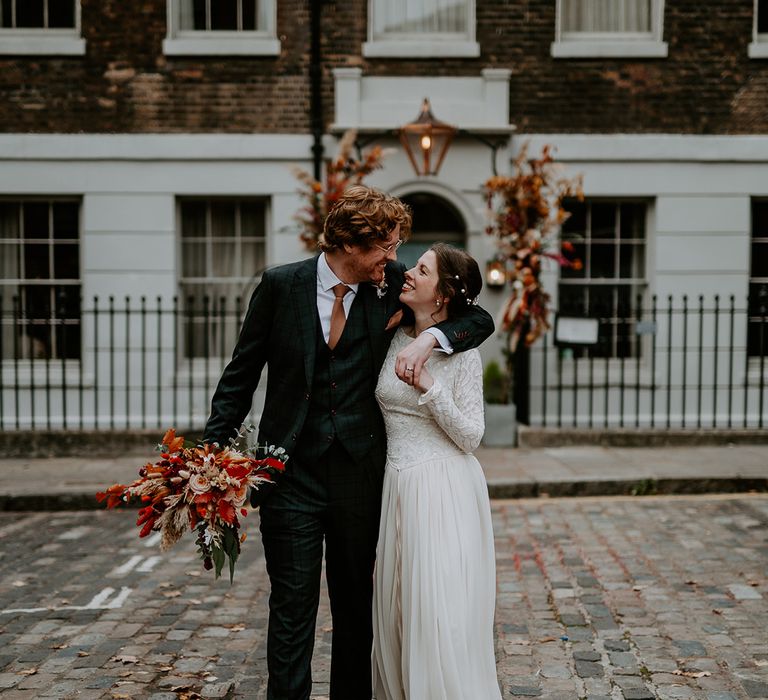 Bride and groom looking into each other's eyes walking outside The Zetter Townhouse at intimate, autumnal London wedding