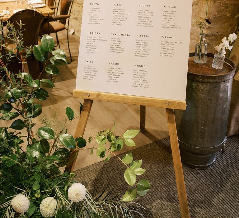 Black and white minimal wedding sign table plan and seating chart with lots of greenery and foliage for rustic luxe wedding 