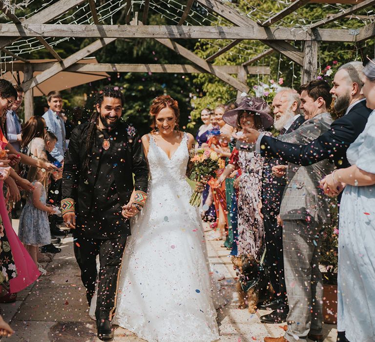 mixed Caribbean groom in black and bride in a white lace wedding dress at Deer Leap Retreat, Devon