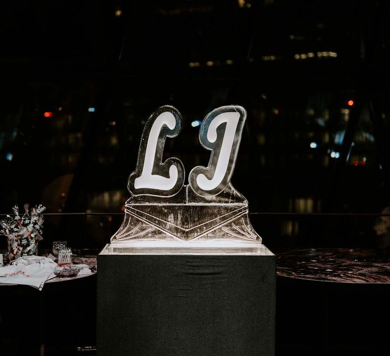 Lit up white and black embossed wedding sign of grooms' initials at The Gherkin wedding venue 