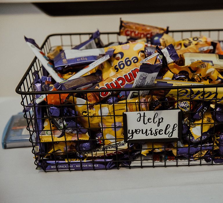 Black metal basked full of chocolate bars for the wedding favours 