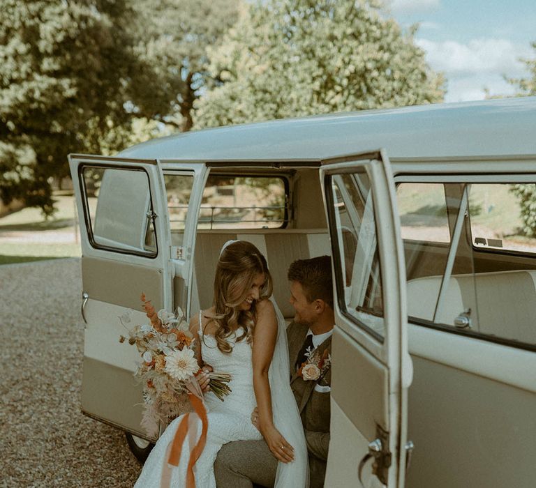 St Tewdrics House Chepstow wedding in Wales with the bride and groom posing next to their vintage camper van wedding transport  